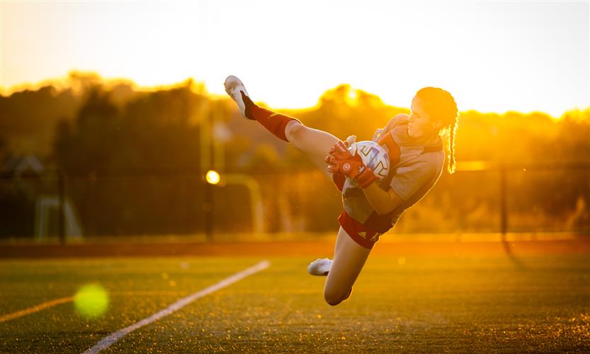 A goalkeeper catches the ball in midair